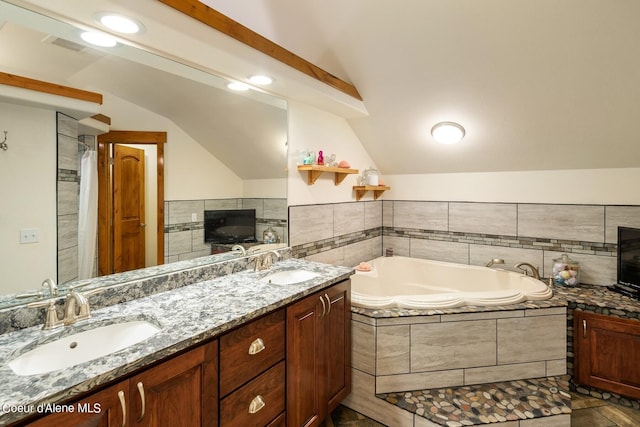 bathroom with lofted ceiling, tiled tub, tile floors, and double sink vanity