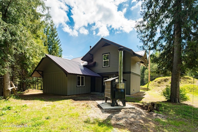 rear view of property featuring a lawn