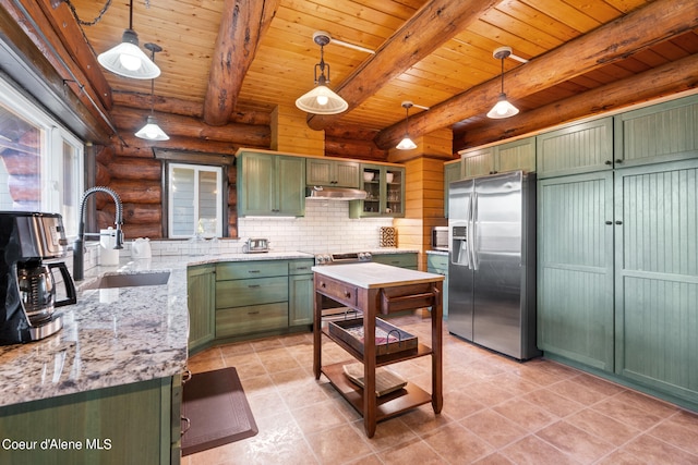 kitchen featuring hanging light fixtures, light stone countertops, sink, stainless steel refrigerator with ice dispenser, and green cabinetry