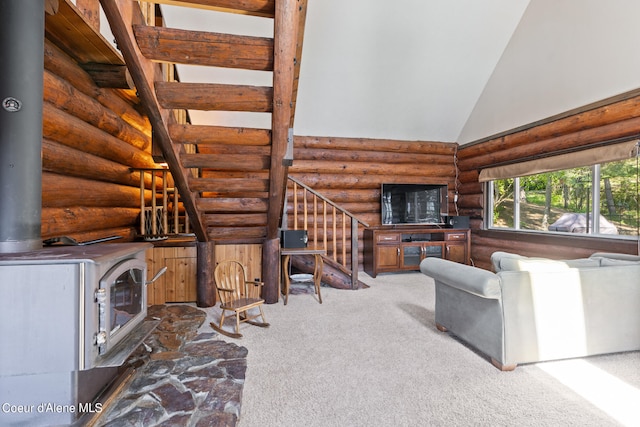 unfurnished living room featuring a wood stove, high vaulted ceiling, carpet flooring, and log walls