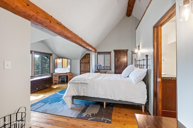 bedroom featuring lofted ceiling with beams and hardwood / wood-style flooring