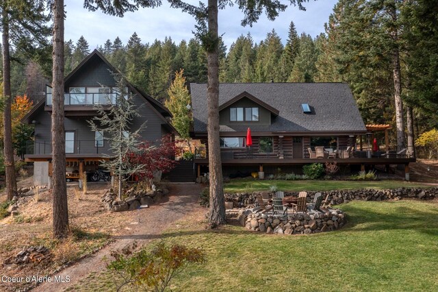 21651 S Lakeview Dr, Worley, ID 83876 - back of property with a yard, a view of trees, and an outdoor fire pit