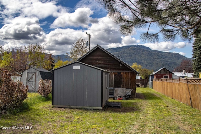 view of outbuilding featuring a lawn and a mountain view