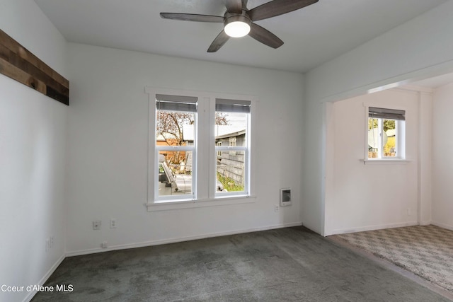 unfurnished room with ceiling fan and dark colored carpet