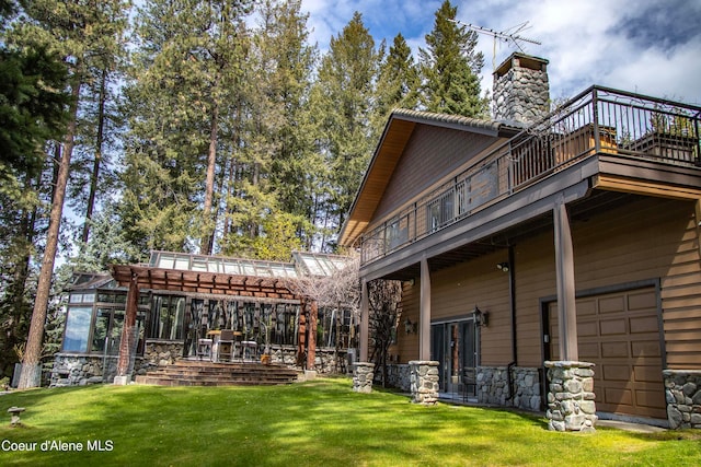 rear view of property featuring a garage and a yard