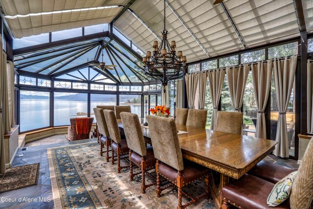 sunroom / solarium featuring a notable chandelier and a water view