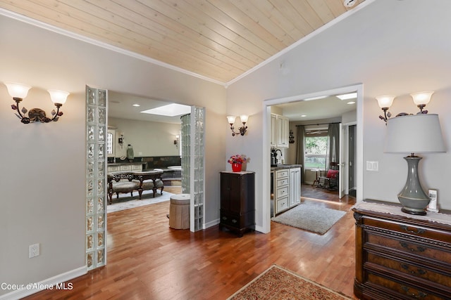 hall featuring ornamental molding, vaulted ceiling, hardwood / wood-style floors, and wooden ceiling