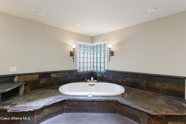 bathroom with a relaxing tiled bath