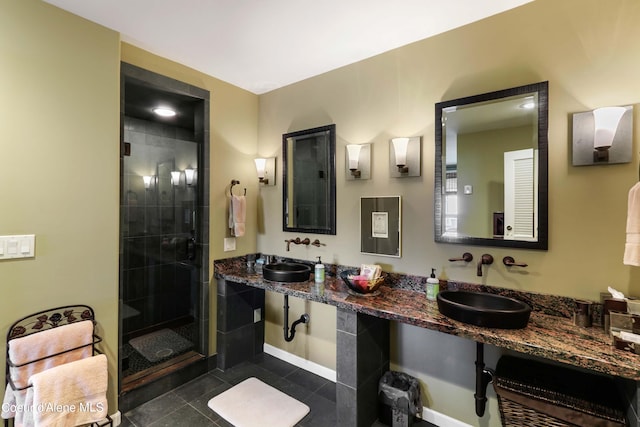 bathroom with double vanity, a shower with door, and tile flooring