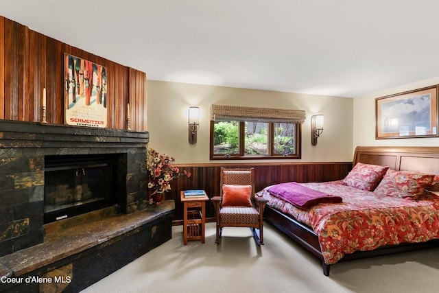 carpeted bedroom featuring wood walls