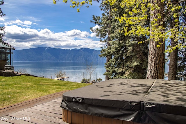 exterior space with a lawn and a water and mountain view