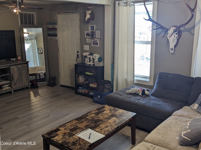 living room featuring ceiling fan and hardwood / wood-style floors