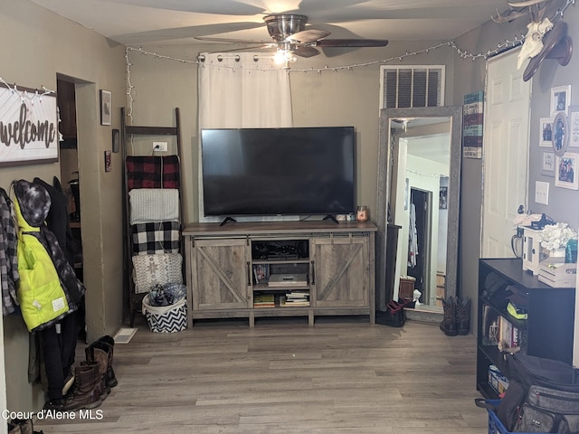 living room with ceiling fan and wood-type flooring