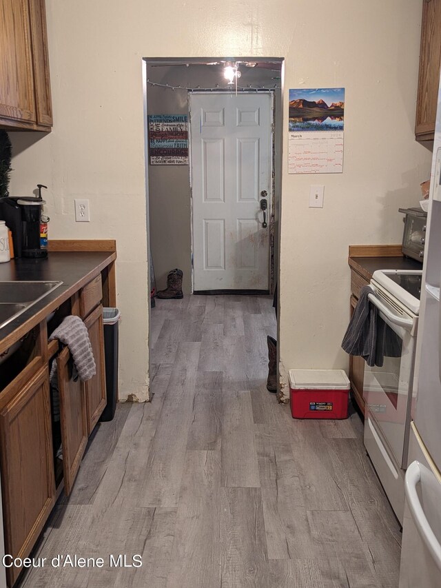 kitchen with white electric range oven and hardwood / wood-style floors