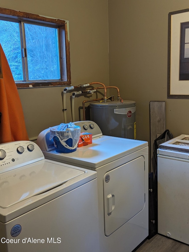 washroom with wood-type flooring, water heater, and washing machine and clothes dryer