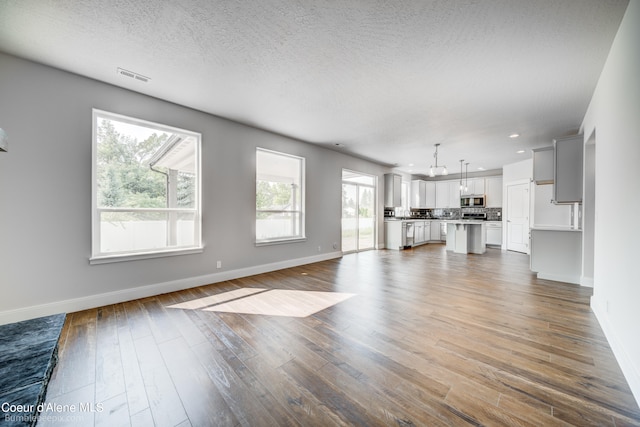 unfurnished living room with a textured ceiling and hardwood / wood-style floors