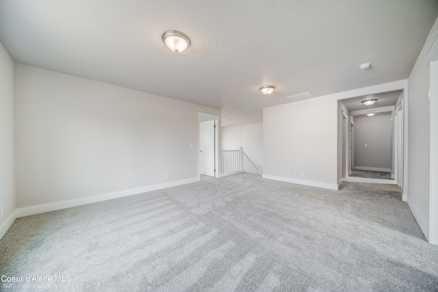 carpeted empty room with a textured ceiling