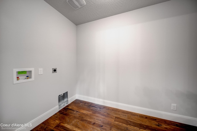 clothes washing area with a textured ceiling, washer hookup, electric dryer hookup, and dark wood-type flooring