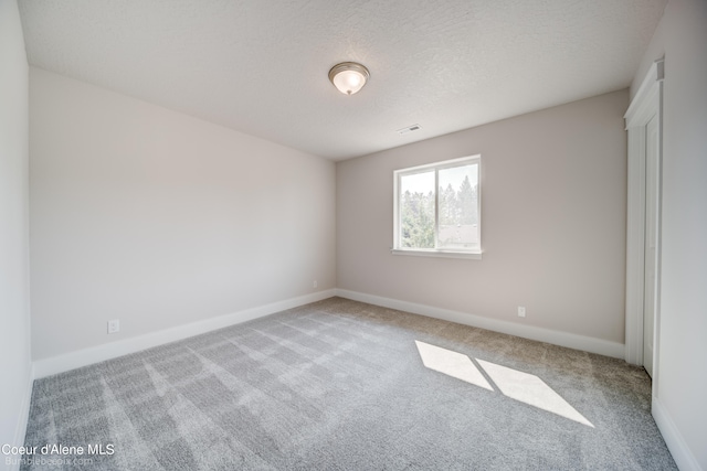 empty room featuring carpet and a textured ceiling