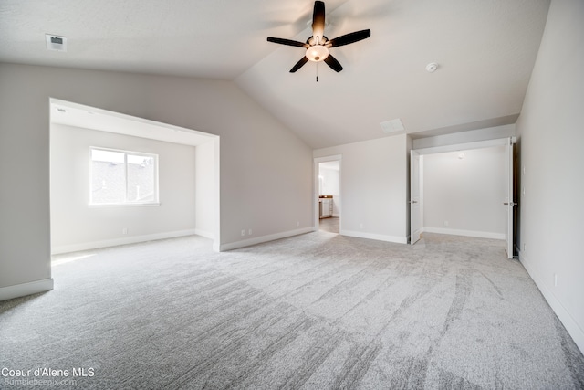 unfurnished living room featuring light colored carpet, vaulted ceiling, and ceiling fan