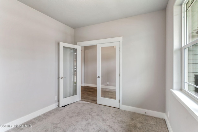 unfurnished bedroom with carpet flooring, french doors, and multiple windows