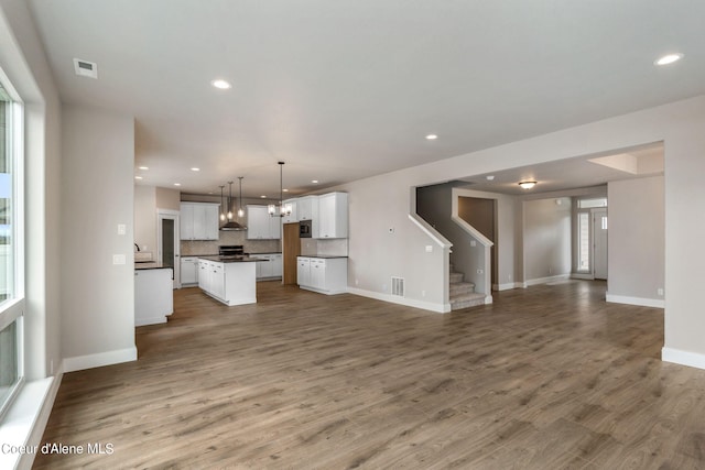 unfurnished living room featuring sink and hardwood / wood-style floors