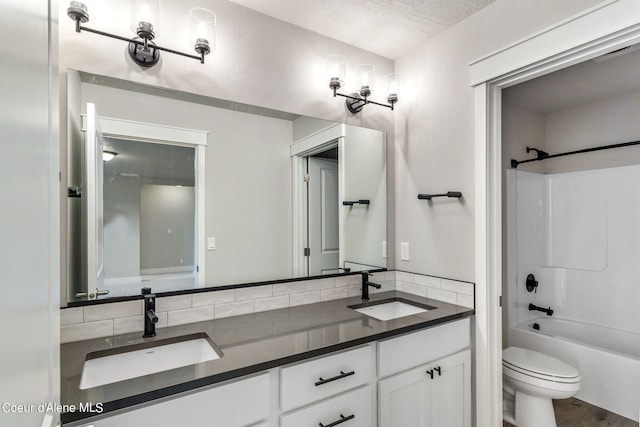 full bathroom with double vanity, shower / bath combination, toilet, wood-type flooring, and a textured ceiling