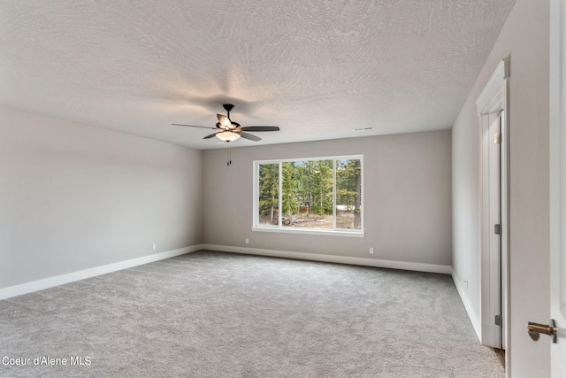 carpeted empty room featuring ceiling fan and a textured ceiling