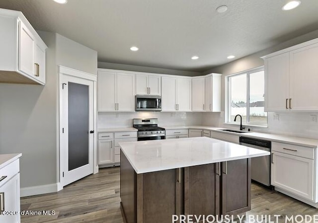 kitchen featuring a center island, white cabinetry, hardwood / wood-style floors, and stainless steel appliances