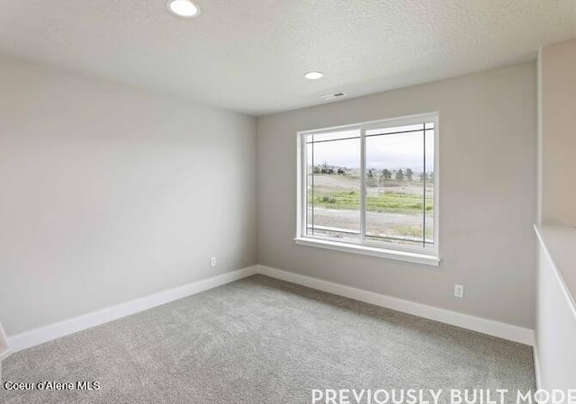 unfurnished room featuring carpet flooring and a textured ceiling