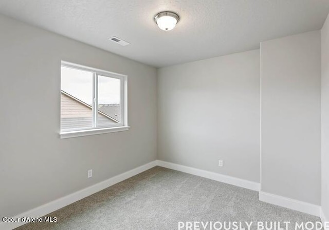 empty room featuring carpet flooring and a textured ceiling