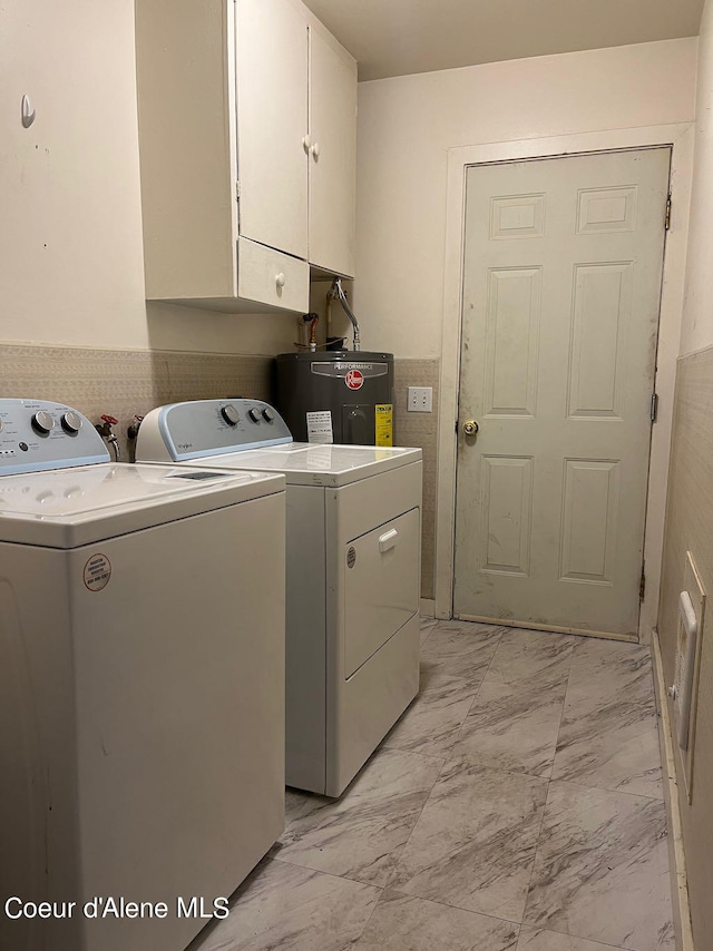 laundry area featuring washer and clothes dryer, electric water heater, light tile flooring, and cabinets