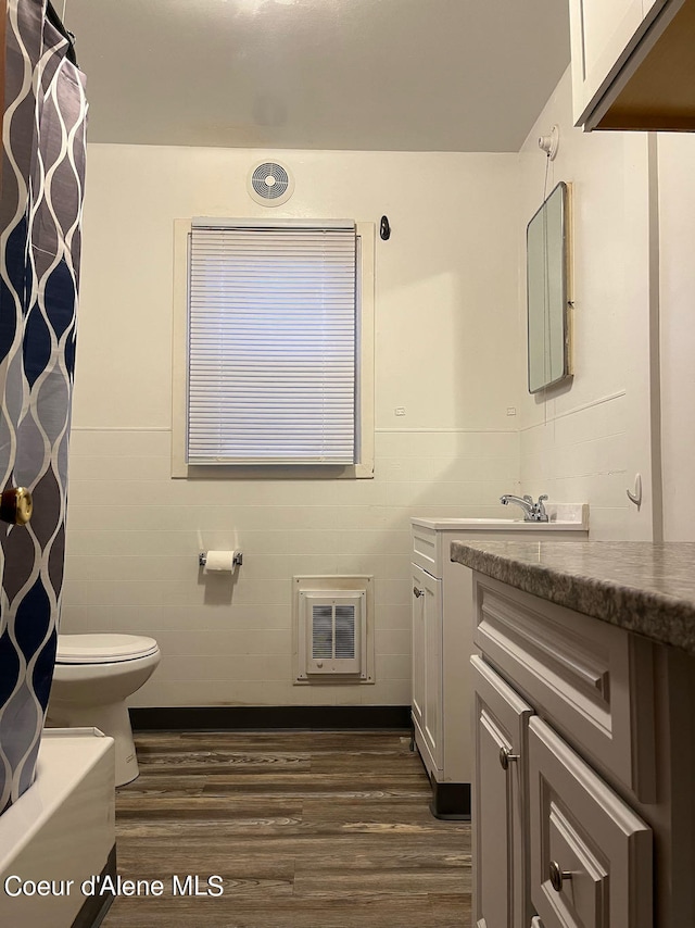 full bathroom with shower / tub combo, wood-type flooring, vanity, and toilet