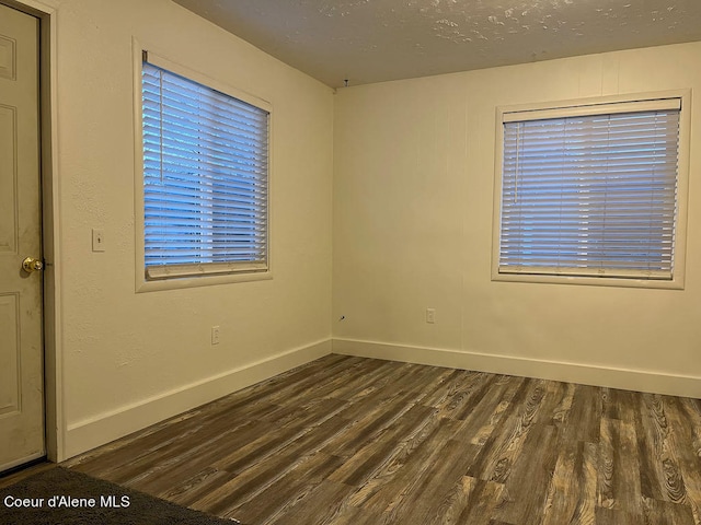 empty room with dark hardwood / wood-style flooring