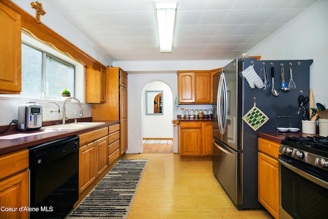 kitchen with light hardwood / wood-style floors, gas range, crown molding, black dishwasher, and sink