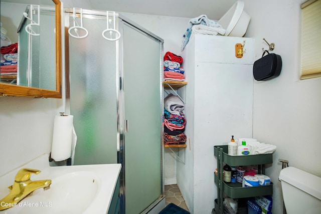 bathroom featuring tile floors, a shower with shower door, oversized vanity, and toilet