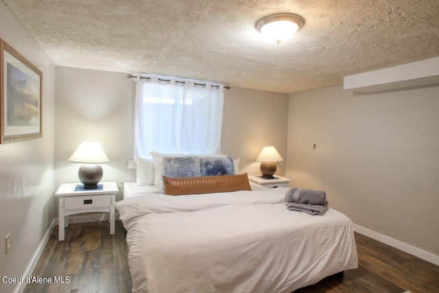 bedroom featuring dark hardwood / wood-style flooring and a textured ceiling