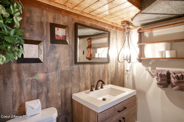 bathroom featuring wood walls, vanity, and toilet