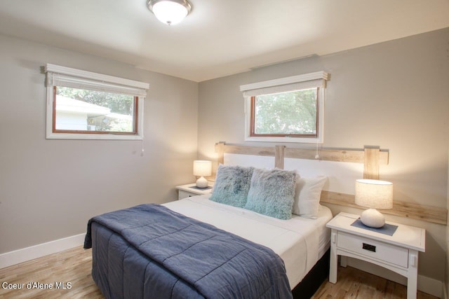 bedroom featuring light hardwood / wood-style flooring and multiple windows