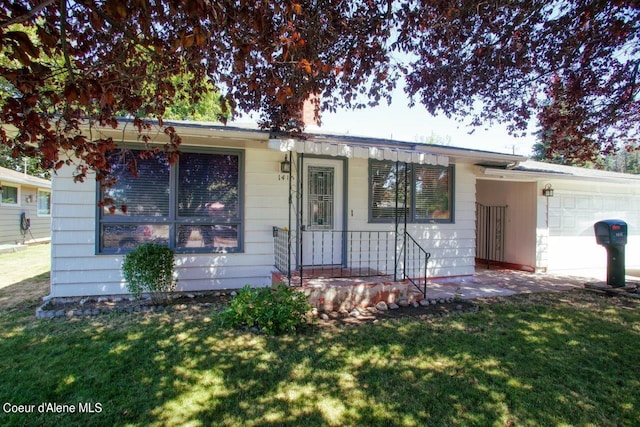 single story home with a front yard and a garage