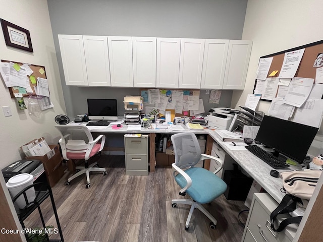 home office featuring dark hardwood / wood-style floors and built in desk