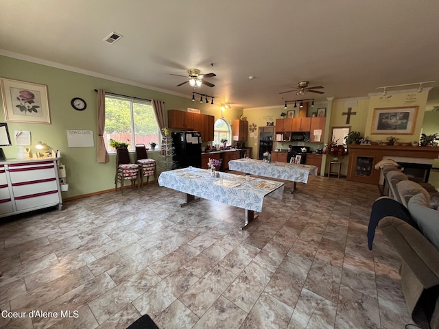 tiled living room featuring crown molding, sink, and ceiling fan