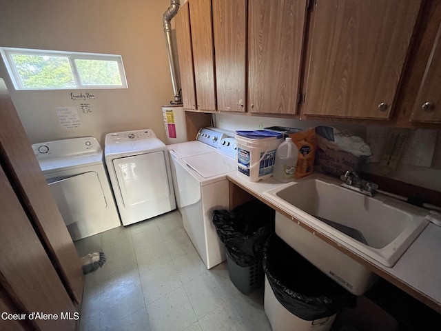 laundry room featuring sink, washer and dryer, cabinets, and light tile floors