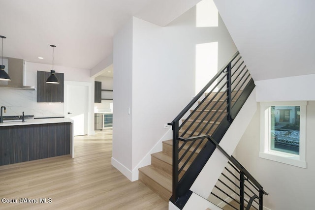 staircase with wood-type flooring and sink