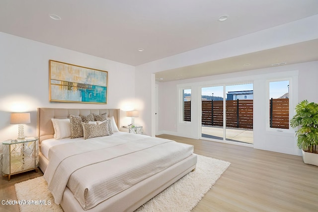 bedroom with access to exterior and light wood-type flooring