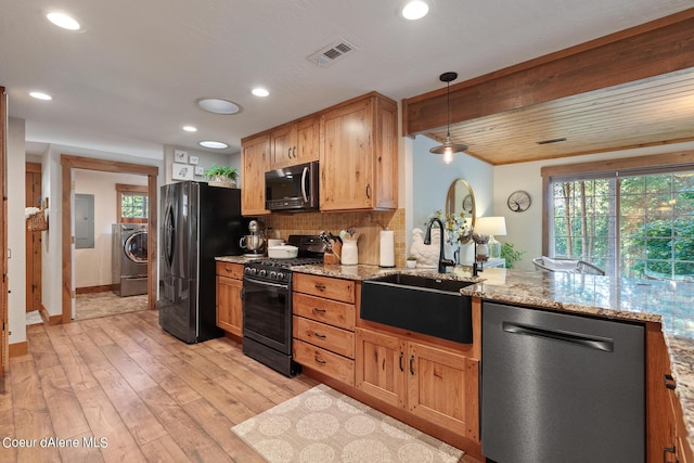 5718 E Sleepy Ln, Coeur Dalene, ID 83814 - kitchen with stainless steel dishwasher, black gas stove, freestanding refrigerator, washer / clothes dryer, and light wood-style flooring