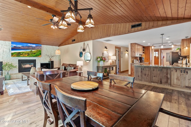 5718 E Sleepy Ln, Coeur Dalene, ID 83814 - dining area featuring light wood-type flooring, vaulted ceiling, ceiling fan, wooden ceiling, and a fireplace