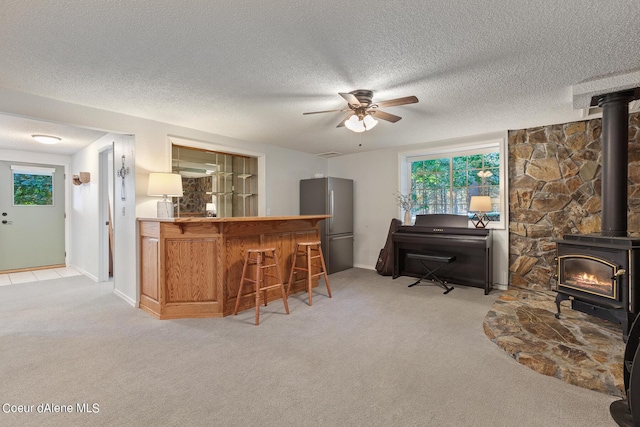 5718 E Sleepy Ln, Coeur Dalene, ID 83814 - indoor bar with a wood stove, high quality fridge, ceiling fan, light carpet, and a textured ceiling