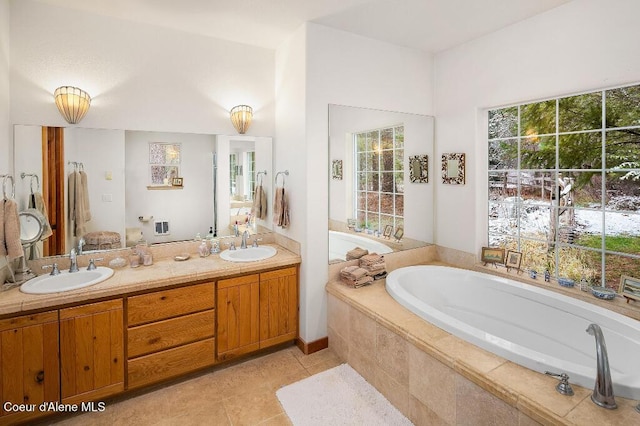 bathroom featuring vanity, tile patterned flooring, and tiled tub