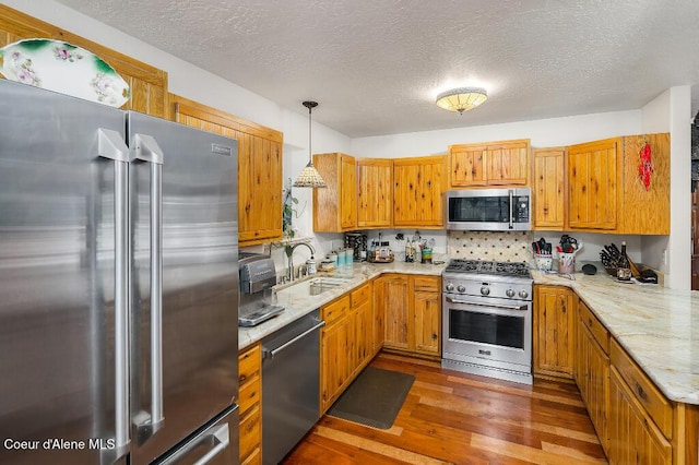 kitchen with a textured ceiling, dark hardwood / wood-style flooring, pendant lighting, and premium appliances